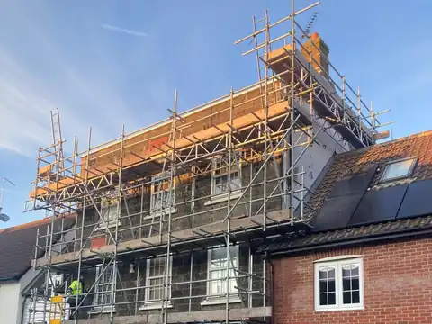 Scaffold up to the roof line of a three-storey house